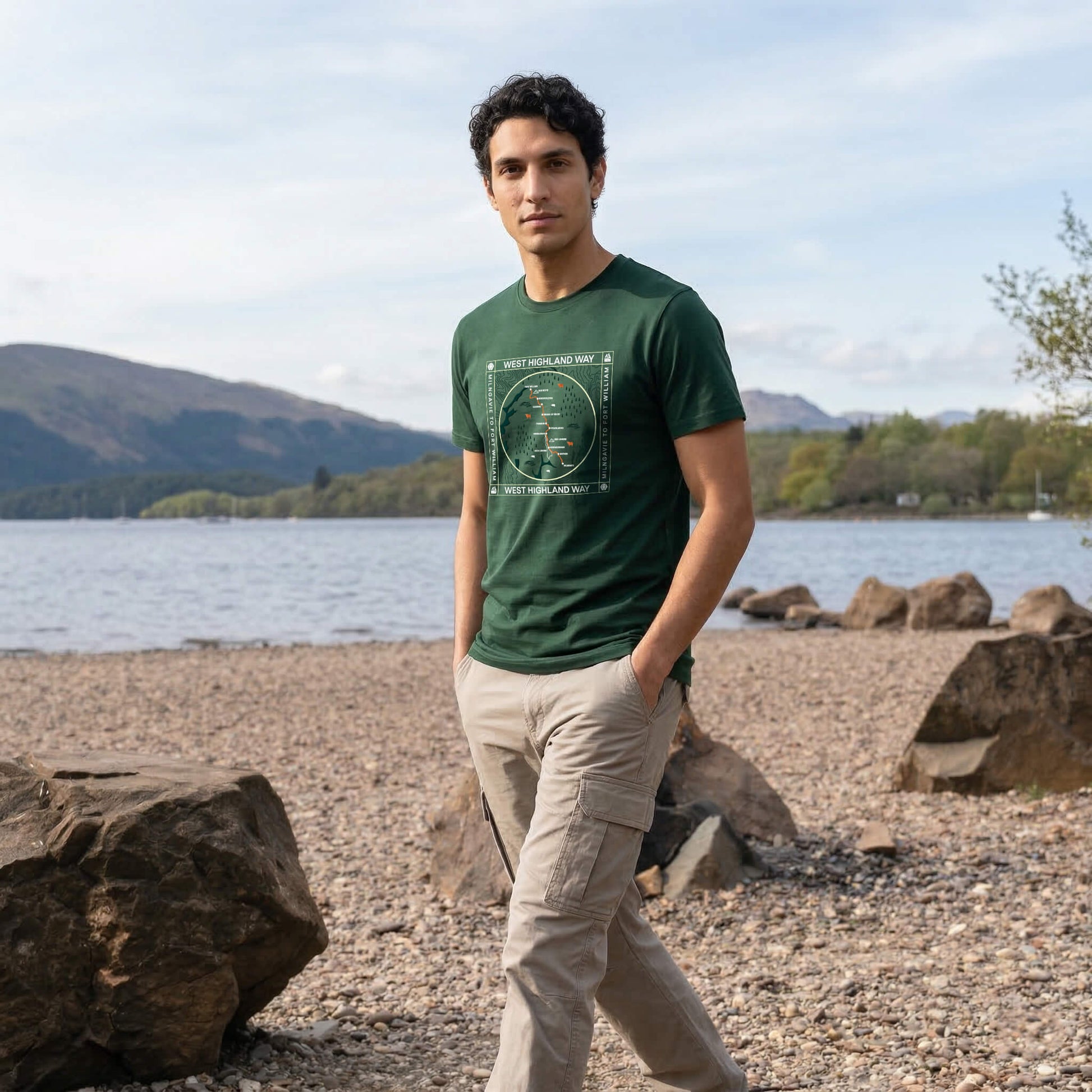 Three quarter view of man wearing forest green west highland way map organic cotton t-shirt