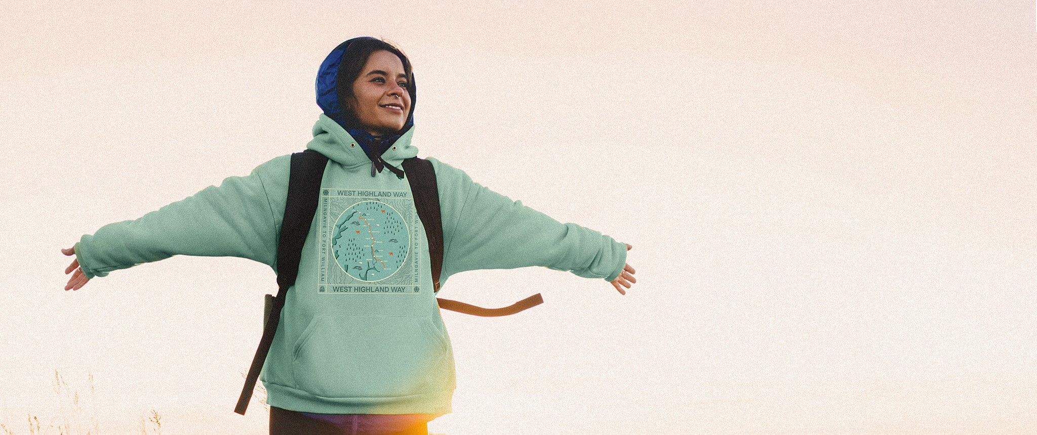Girl with open arms wearing the West Highland Way Map Organic Cotton Hoodie